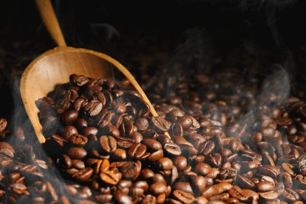 Wooden scoop over coffee beans